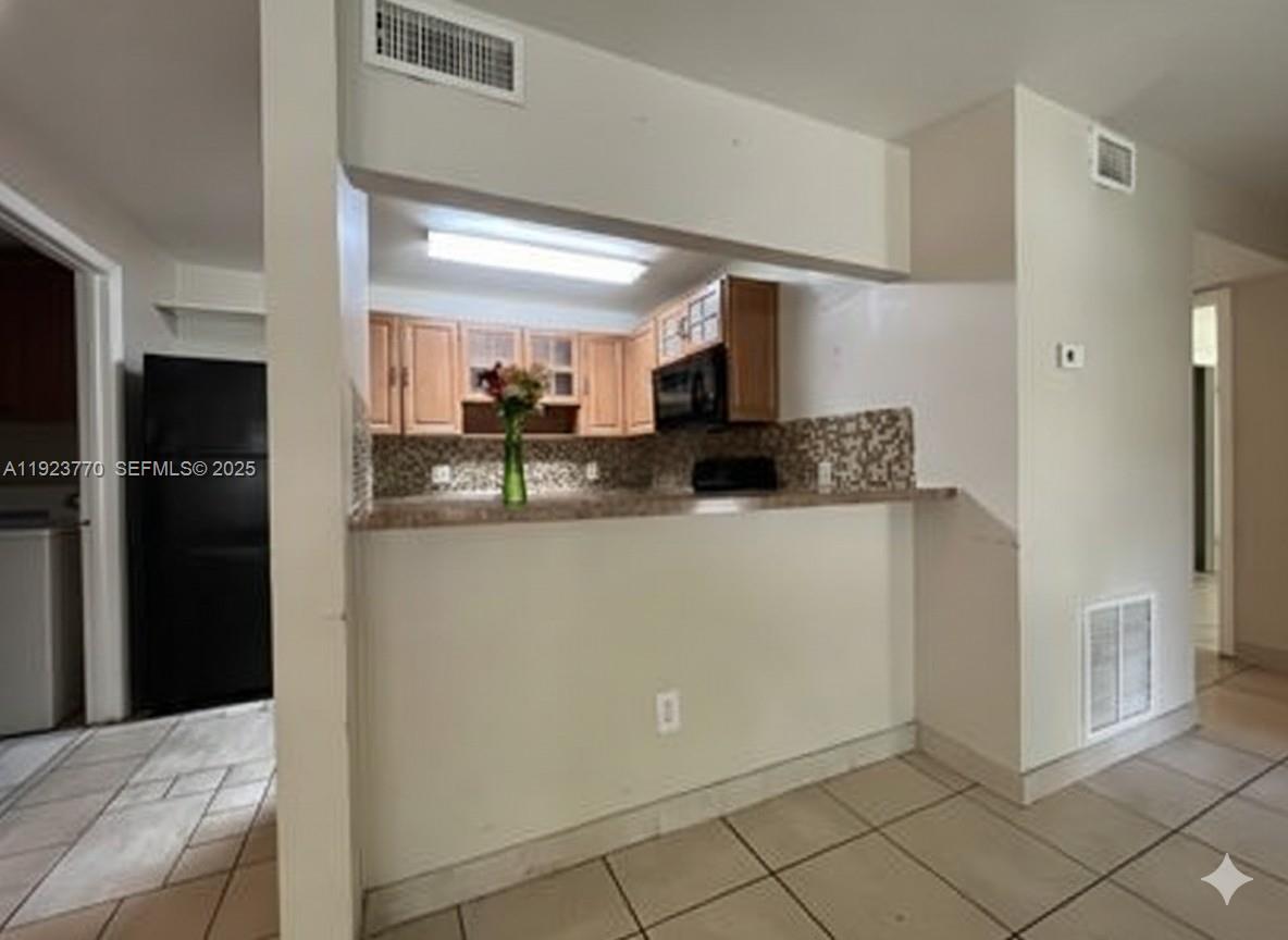 4201 West McNab Road, Unit 15 Pompano Beach, FL 33069 - Photo 7 of 18 a kitchen with stainless steel appliances granite countertop a refrigerator and a sink