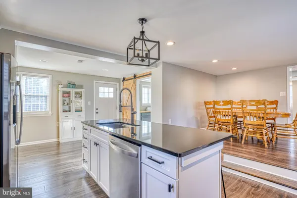 a kitchen with a table chairs wooden floor and appliances