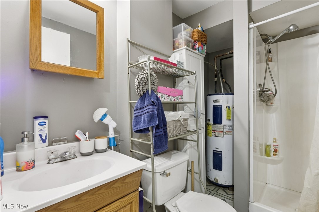 6370 Trumbull Road Geneva, OH 44041 - Photo 35 of 50 Bathroom featuring a stall shower, vanity, and water heater