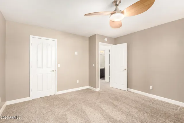 an empty room with a fan & a ceiling fan