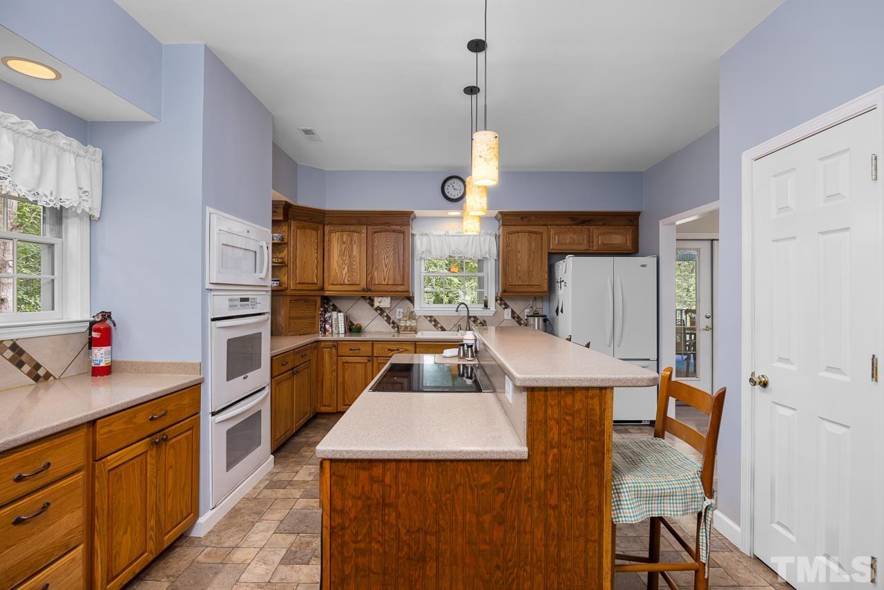 1008 Windstar Way Willow Spring, NC 27592 - Photo 8 of 51 a kitchen that has a sink a center island stainless steel appliances and a window