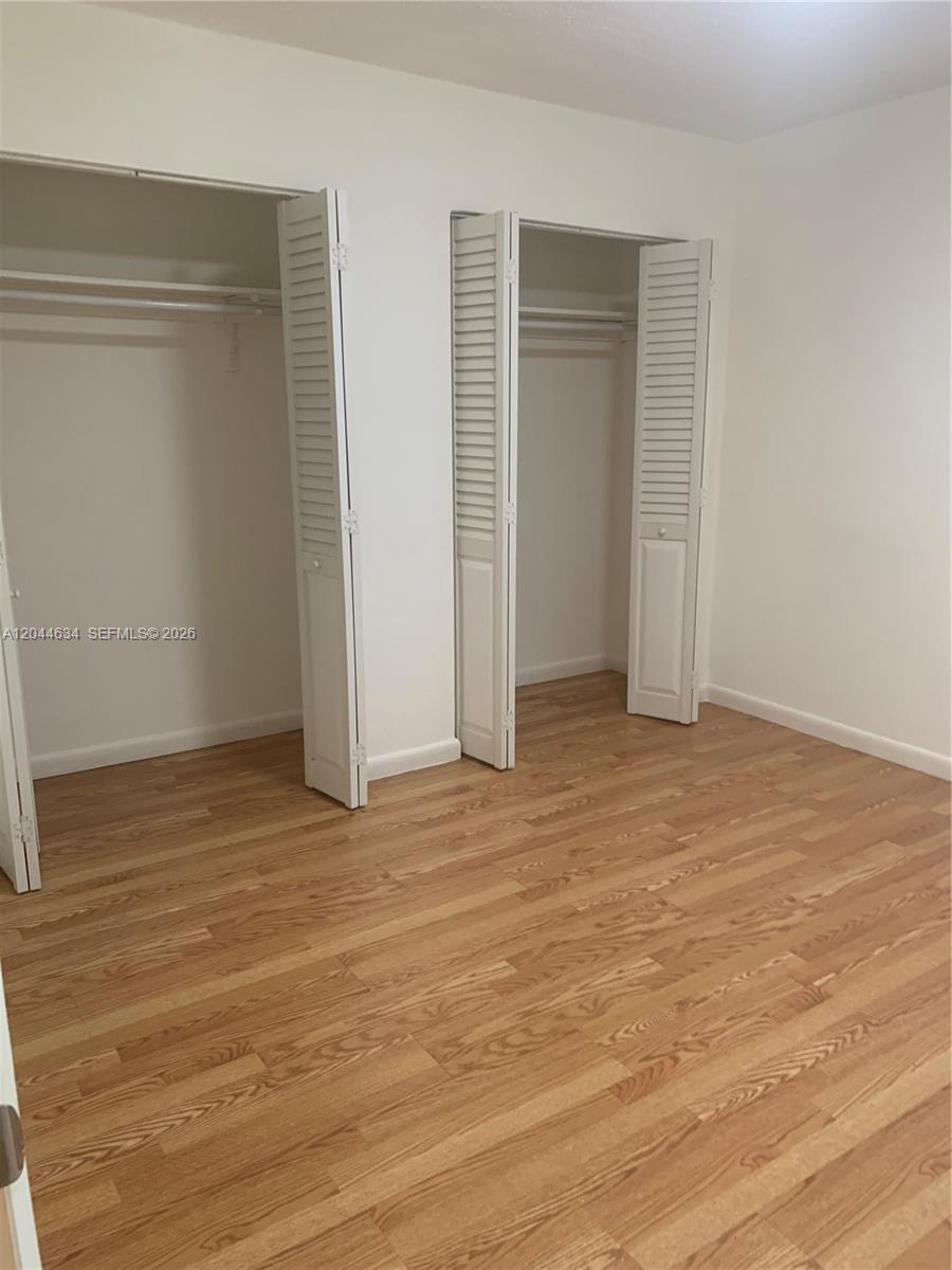 2460 Southwest 18th Avenue, Unit 1205 Miami, FL 33133 - Photo 14 of 21 an empty room with wooden floor and closet