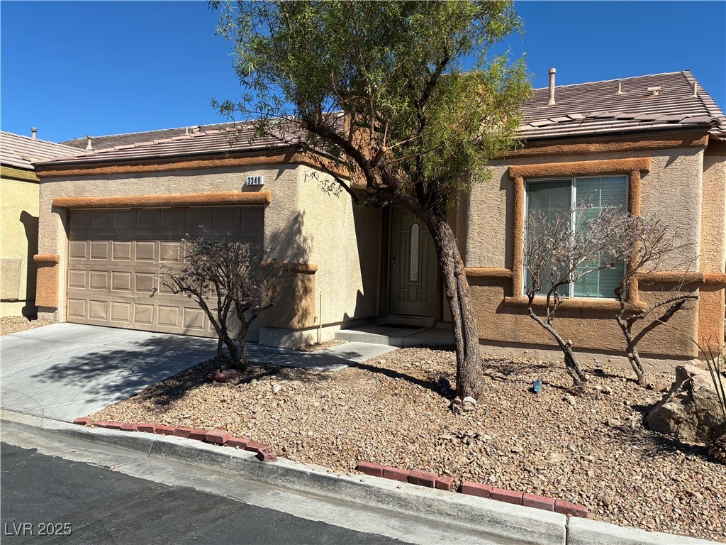View of front of home featuring driveway, stucco siding, an attached garage, and a tile roof