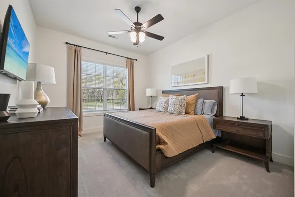 a spacious bedroom with a bed a couch and a window