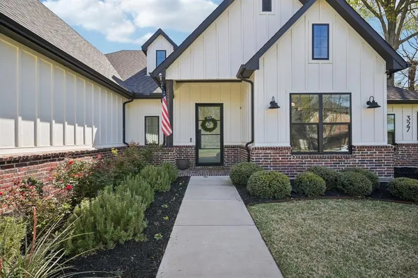 a view of a house with brick walls and a yard