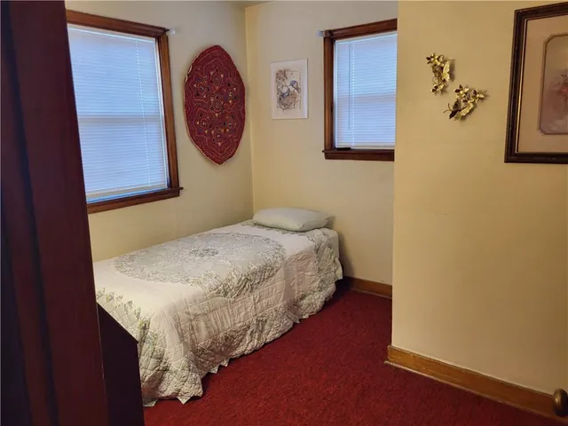 a bedroom with a bed and painting on the wall