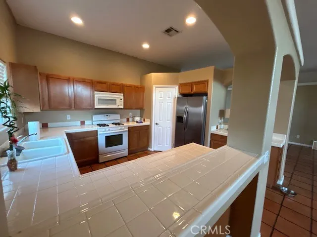a kitchen with stainless steel appliances granite countertop a refrigerator and a stove top oven