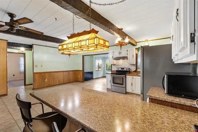 a open kitchen with stainless steel appliances granite countertop a refrigerator and a stove top oven