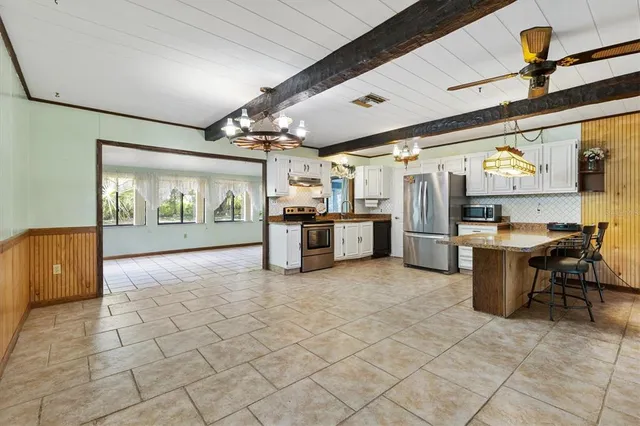 a kitchen with stainless steel appliances granite countertop a stove refrigerator and microwave