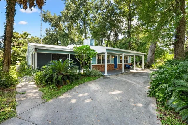 a view of a house with a yard and potted plants