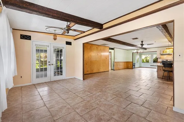 a view of a hallway with wooden floor and a kitchen
