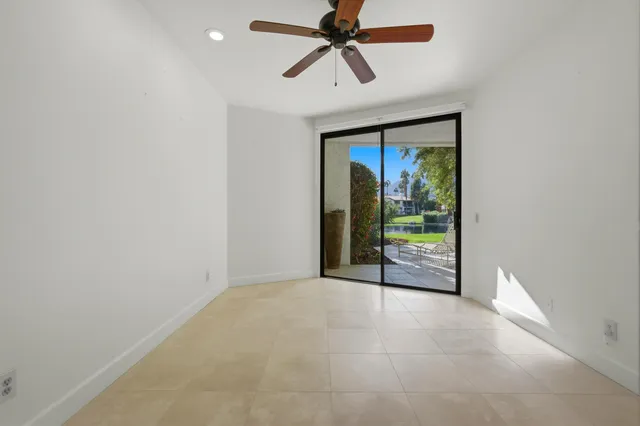 an empty room with closet and fan
