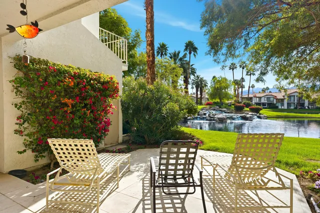a view of a chair and table in the backyard of the house