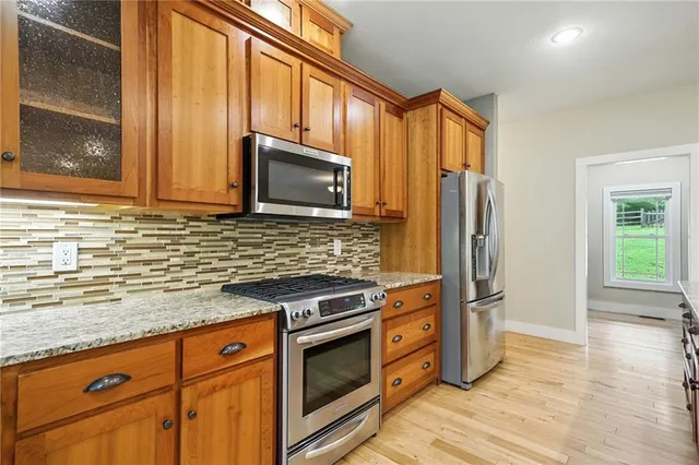 a view of a hallway with bathroom and wooden floor