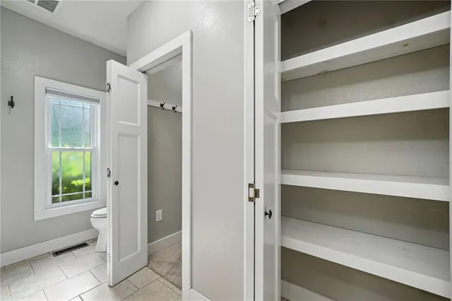 an empty room with a chandelier fan and a ceiling fan