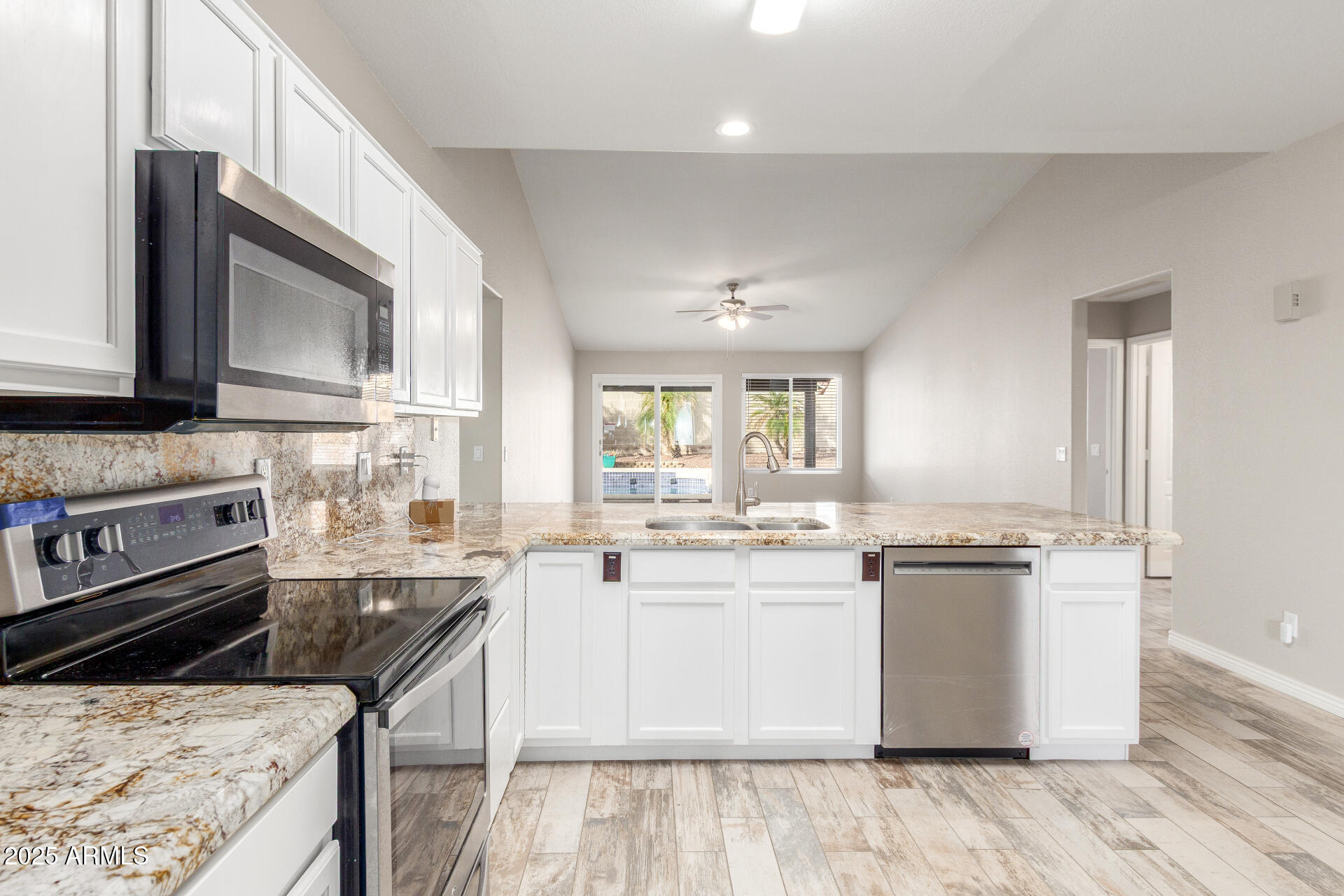11232 East Dover Street Mesa, AZ 85207 - Photo 11 of 31 a kitchen with stainless steel appliances granite countertop a stove a sink dishwasher and a microwave oven with wooden floor