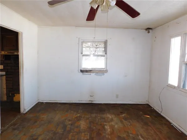 an empty room with a window and a ceiling fan