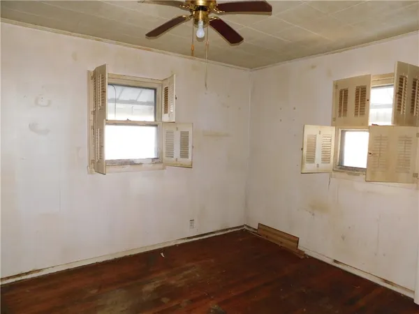 a view of an empty room with a window and wooden floor
