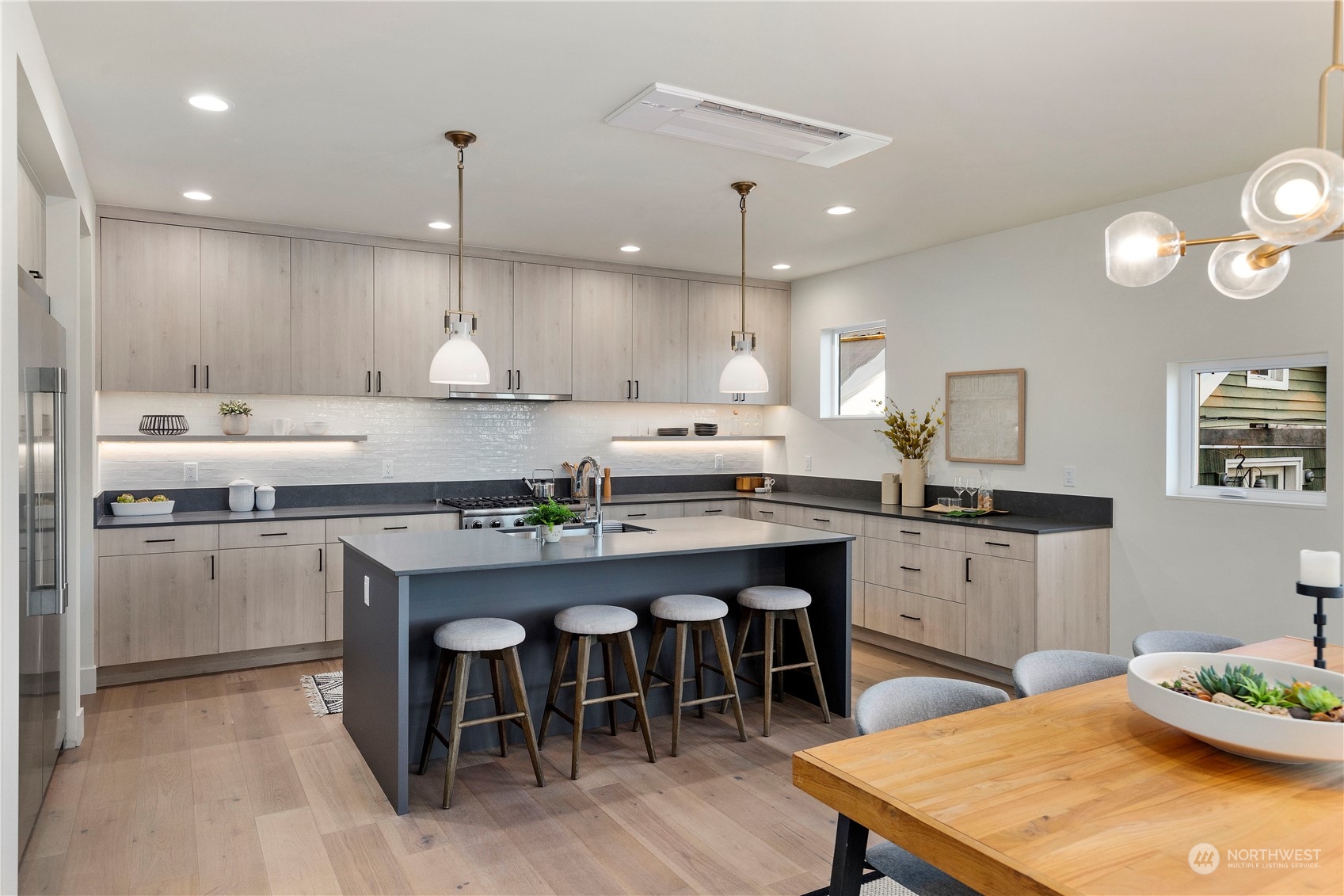 2308 North 38th Street Seattle, WA 98103 - Photo 4 of 40 a kitchen with stainless steel appliances kitchen island granite countertop a table chairs sink and cabinets
