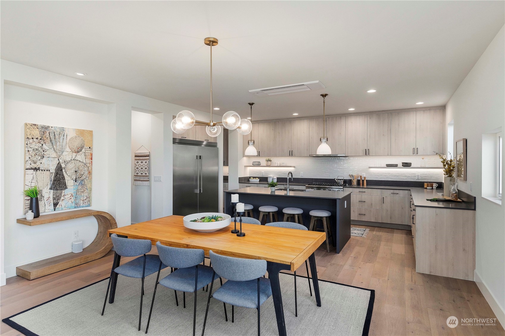 2308 North 38th Street Seattle, WA 98103 - Photo 6 of 40 a kitchen with stainless steel appliances a dining table chairs stove refrigerator and microwave