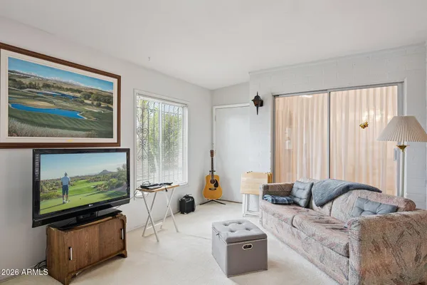 a living room with furniture a window and a flat screen tv