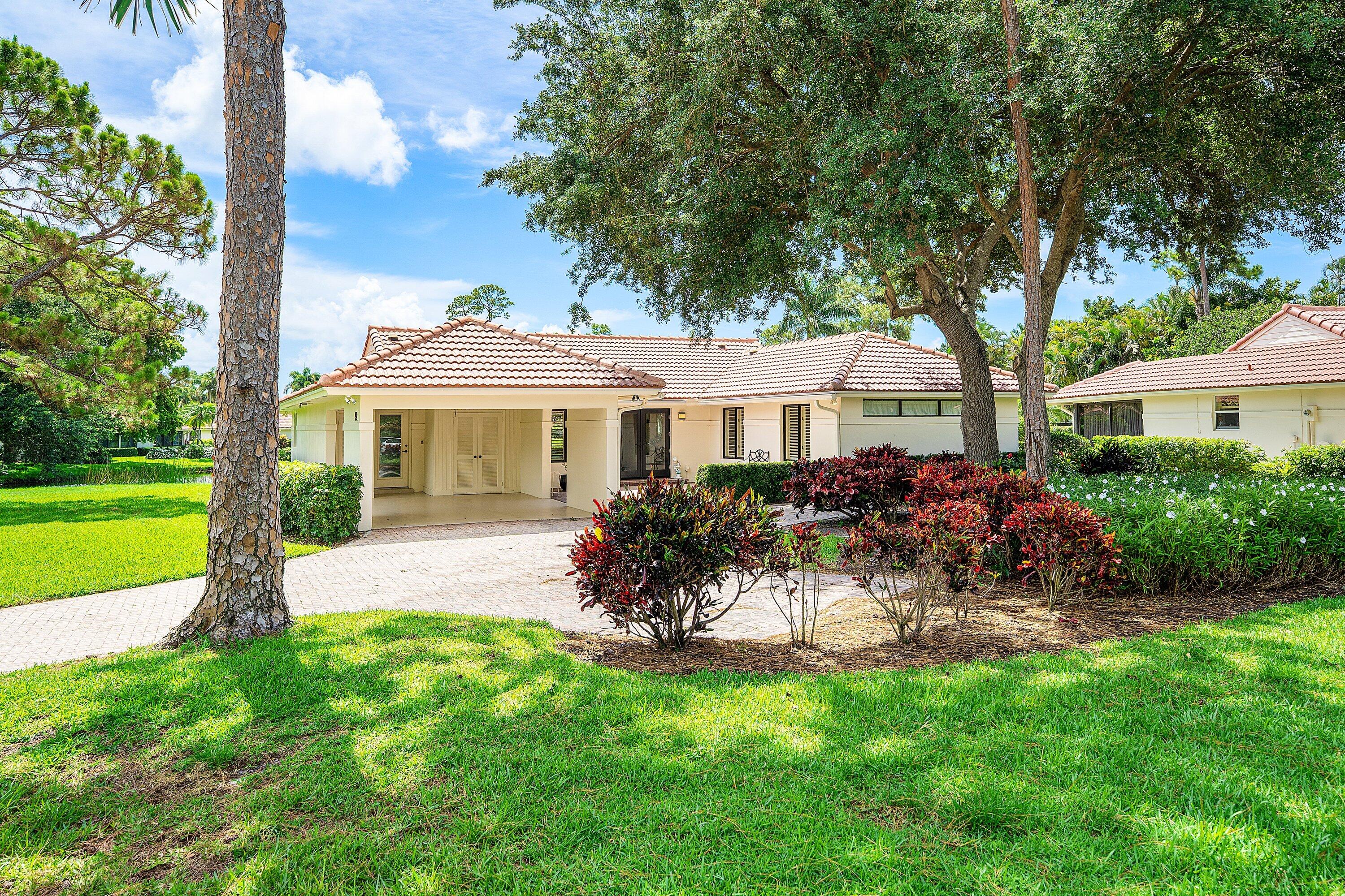 4365 Shell Drake Lane Boynton Beach, FL 33436 - Photo 44 of 56 a front view of a house with a garden and porch
