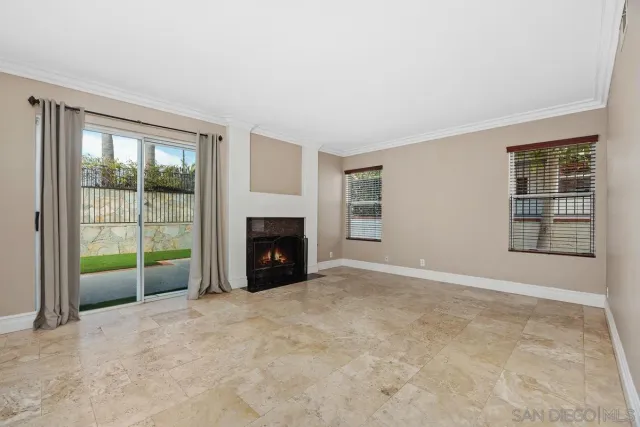 a view of an empty room with a fireplace and a window