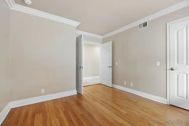 a view of an empty room with wooden floor