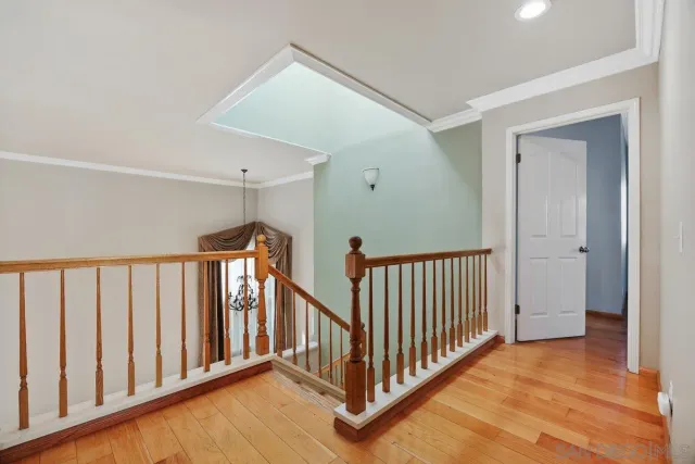 a view of a hallway with wooden floor and stairs