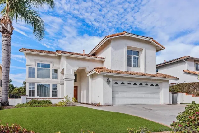 a view of white house with a big yard and large trees