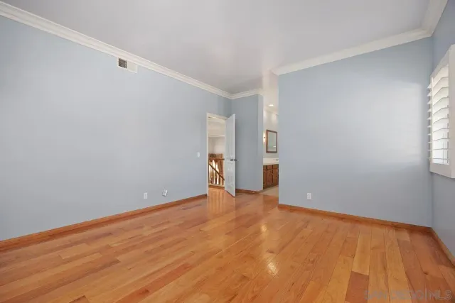 a view of an empty room with wooden floor