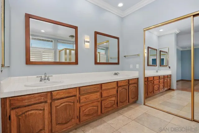 a spacious bathroom with double vanity and a mirror