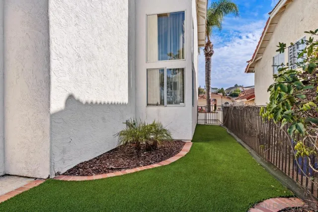 a view of a backyard with potted plants and wooden fence