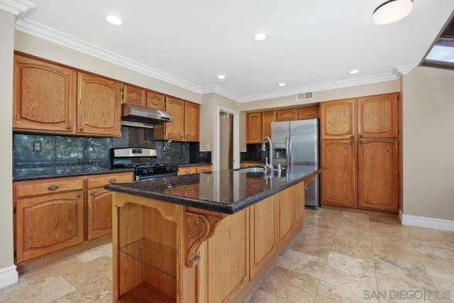 a kitchen with stainless steel appliances granite countertop a sink and cabinets