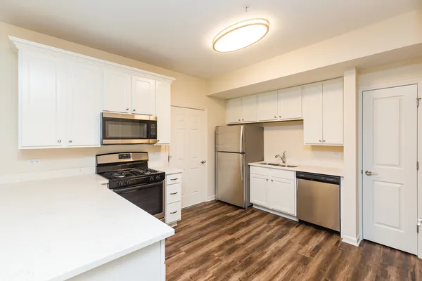a kitchen with a refrigerator stove and white cabinets