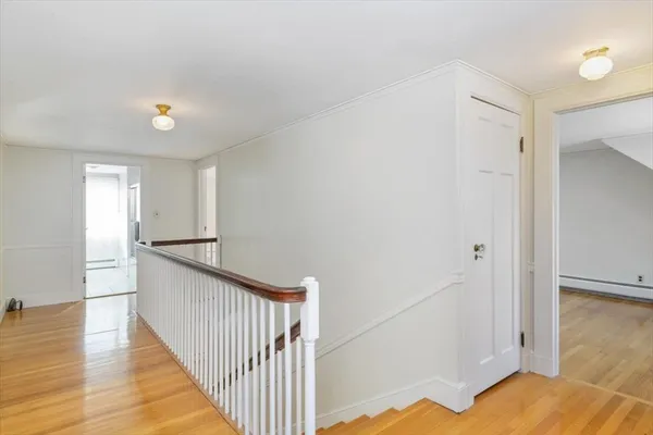 a view of a hallway with wooden floor and staircase