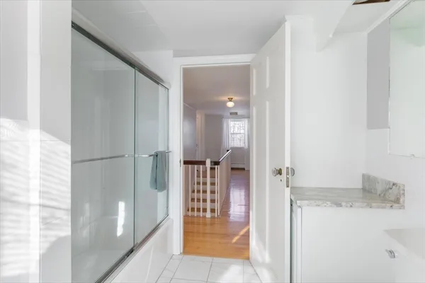 a bathroom with a tub shower and sink