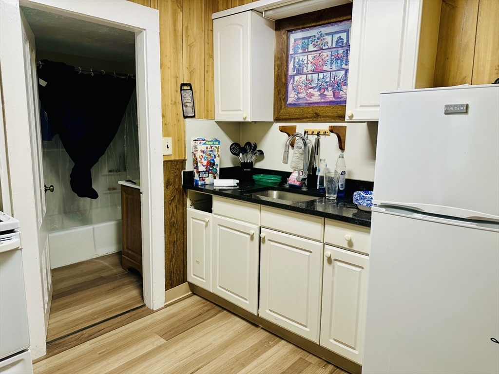 693 Concord Street Framingham, MA 01702 - Photo 13 of 19 a kitchen with white cabinets and refrigerator