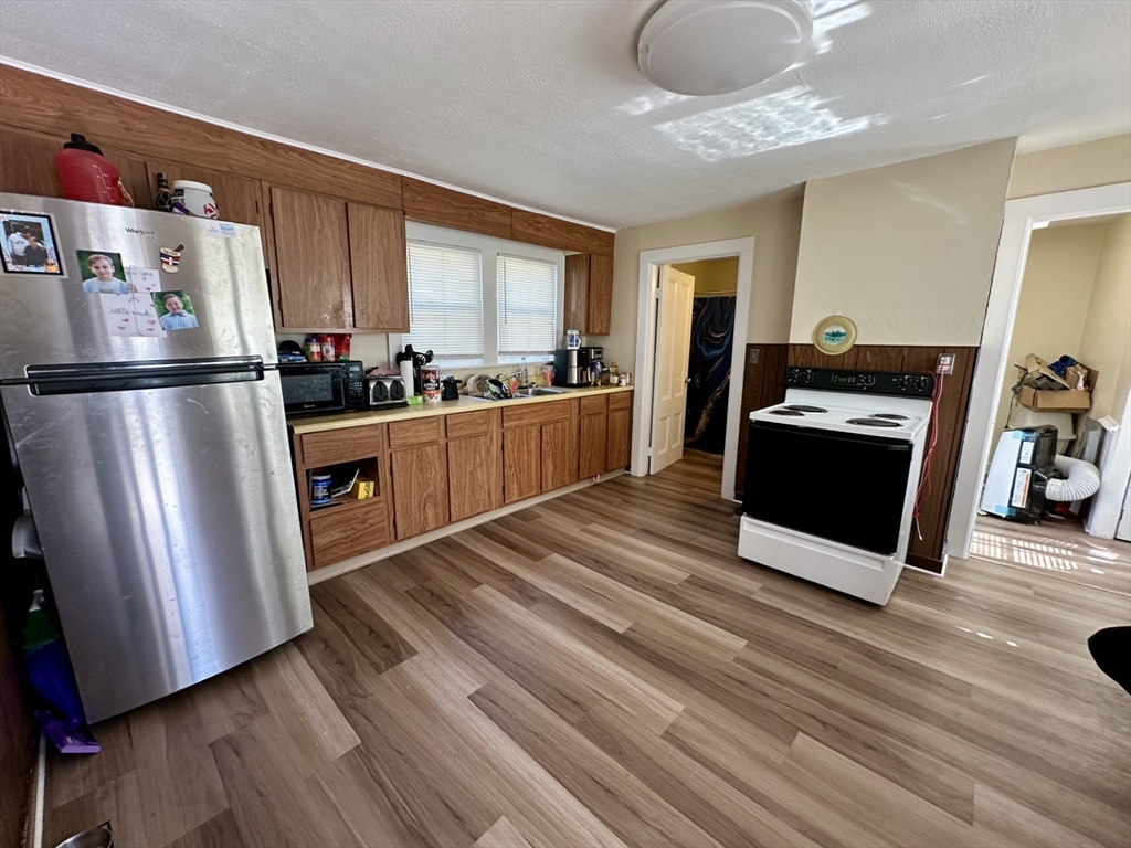 693 Concord Street Framingham, MA 01702 - Photo 2 of 19 a kitchen with stainless steel appliances granite countertop a refrigerator a stove and a wooden floors