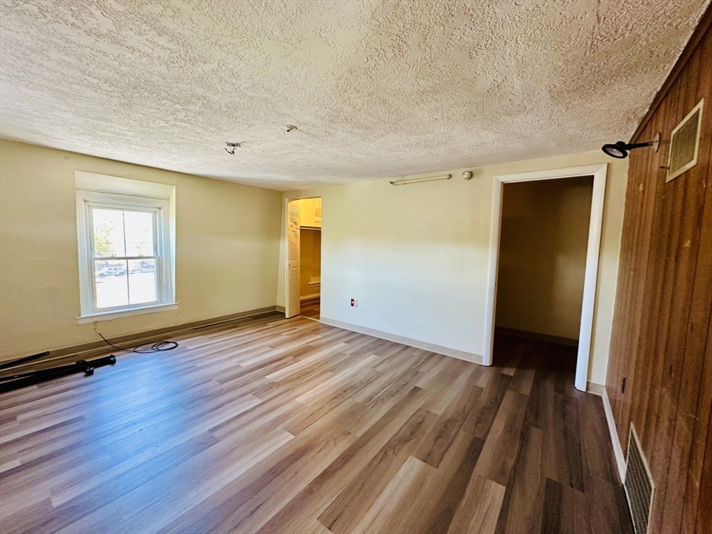 693 Concord Street Framingham, MA 01702 - Photo 3 of 19 an empty room with wooden floor and a window