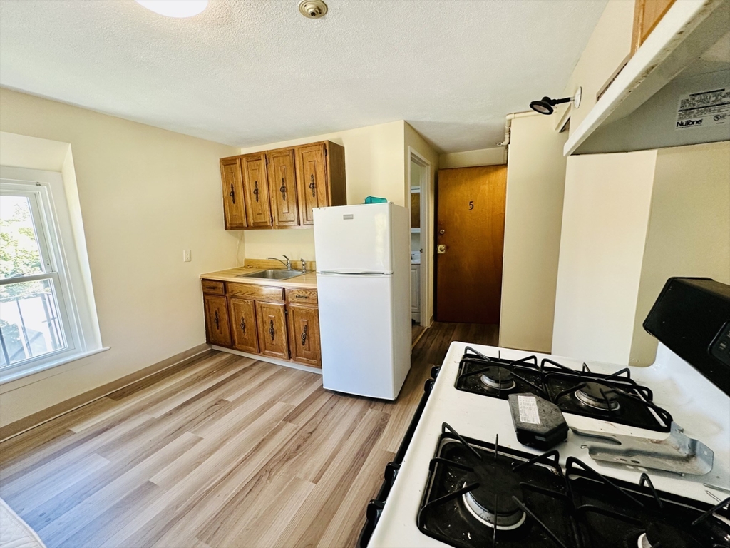 693 Concord Street Framingham, MA 01702 - Photo 4 of 19 a room with wooden floor and white appliances