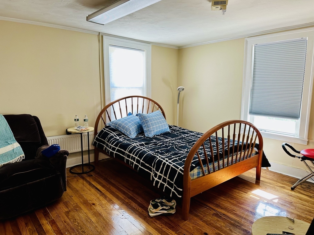 693 Concord Street Framingham, MA 01702 - Photo 7 of 19 a bedroom with a bed and wooden floor