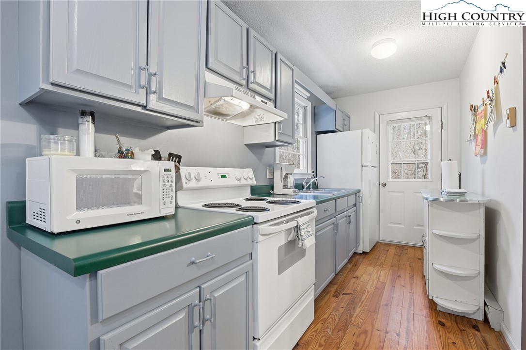 476 Moon Ridge Road Crumpler, NC 28617 - Photo 6 of 35 a kitchen with granite countertop white cabinets and white appliances