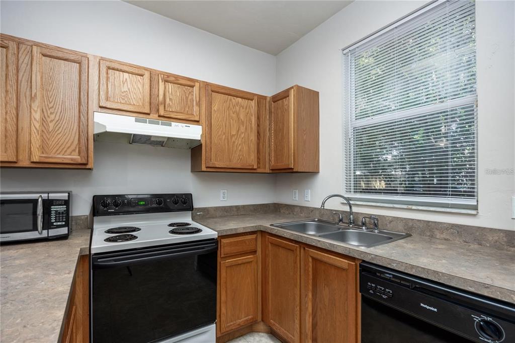 3510 Southwest 30th Way, Unit 158 Gainesville, FL 32608 - Photo 13 of 27 a kitchen with stainless steel appliances granite countertop white cabinets and a stove top oven