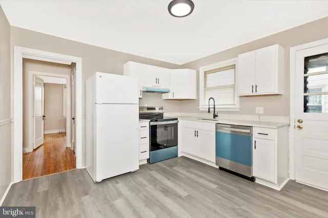 a kitchen with a refrigerator stove and white cabinets