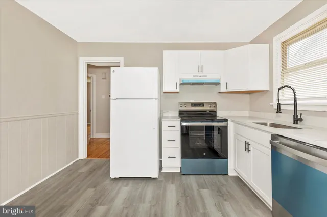a kitchen with a refrigerator and a stove top oven