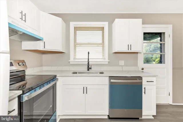 a kitchen with stainless steel appliances granite countertop a sink stove and cabinets