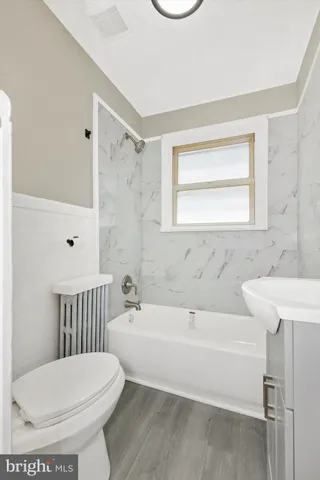 a bathroom with a toilet a sink and bathtub