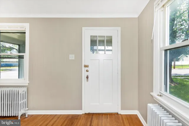 an empty room with windows and wooden floor