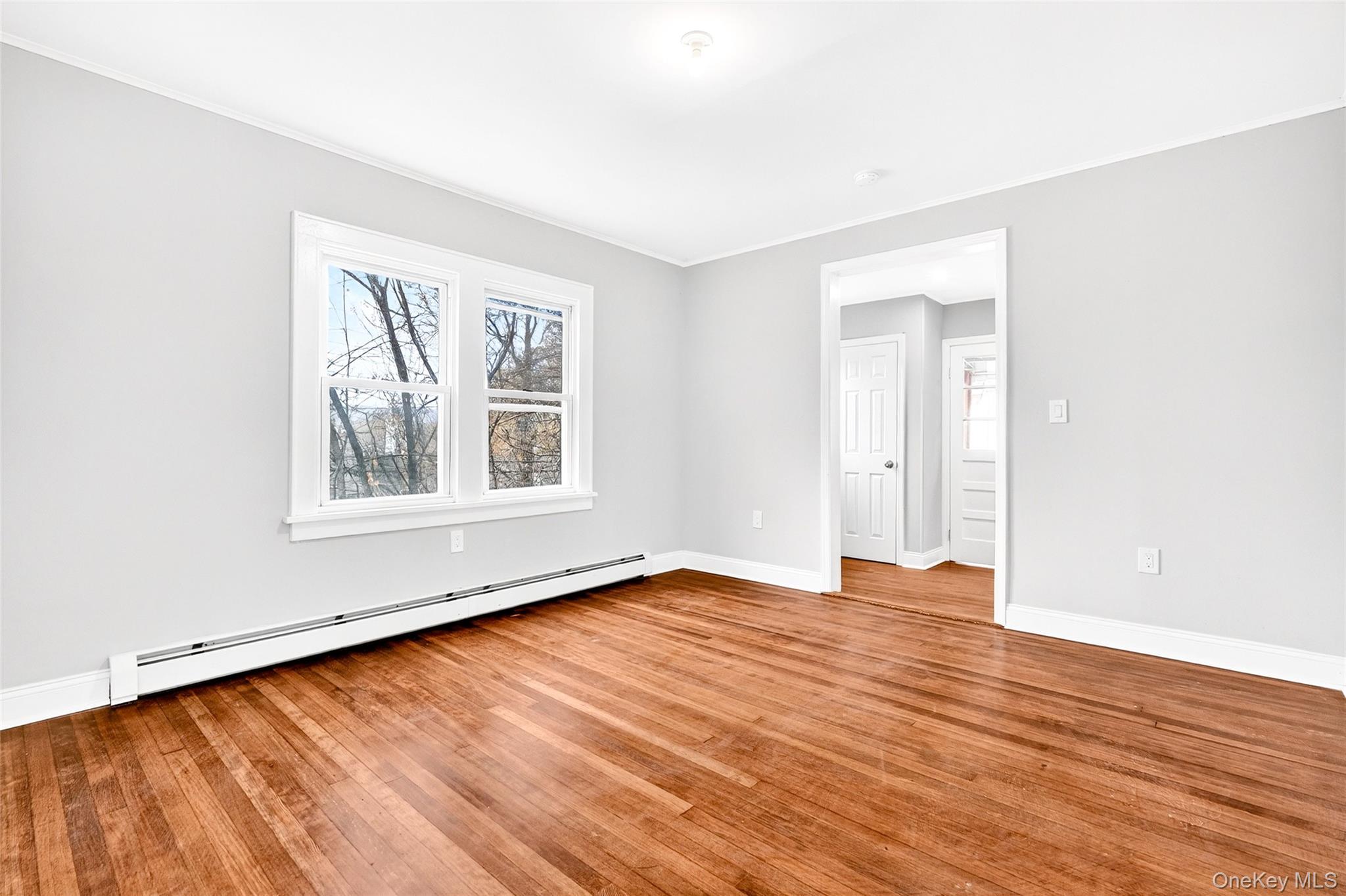 669 North Division Street Peekskill, NY 10566 - Photo 18 of 48 an empty room with wooden floor and windows
